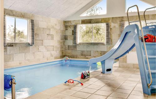 a indoor swimming pool with a slide in a room at Beautiful Home In Idestrup With Sauna in Marielyst