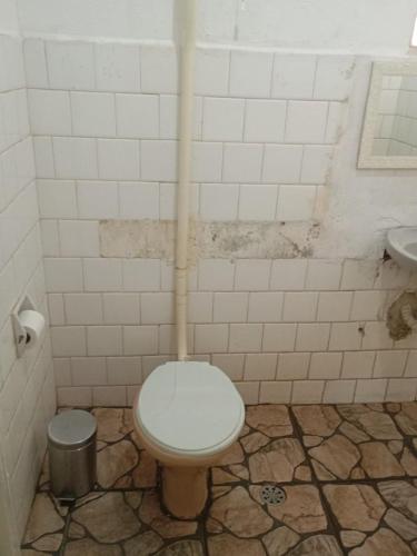 a dirty bathroom with a toilet and a sink at CasaSueli in Aparecida