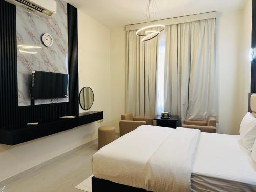 a hotel room with a bed and a tv at Al Zahra Hotel Apartments Ras Al Khaimah in Ras al Khaimah