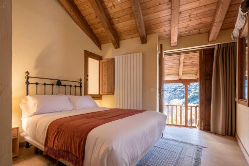 a bedroom with a bed and a large window at Fogar Mozárabe in Peñalba de Santiago