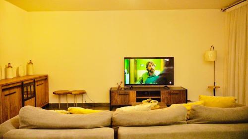 キンシャサにあるLa résidence kin maleboのソファと薄型テレビのあるリビングルーム