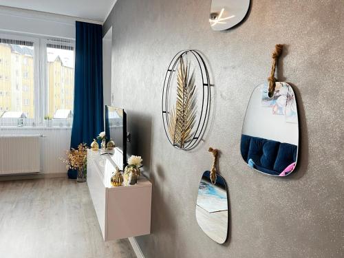 a room with mirrors on the wall and a blue chair at A&R Apartamenty Wenedów III, bezpłatny prywatny parking in Koszalin