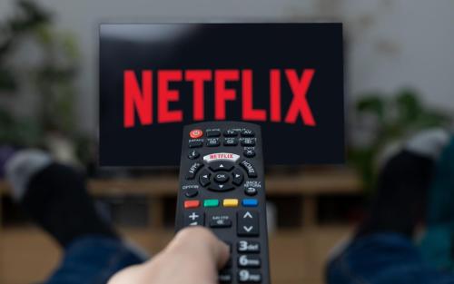 a person holding a remote control in front of a tv at Monnalisa House - Imola Centro Storico - Appartamento Indipendente in Imola