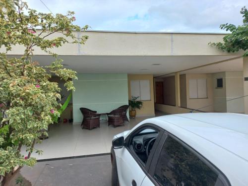 a white car parked in front of a house at Casa em condomínio in Cuiabá