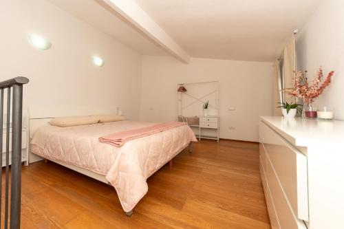 a white bedroom with a bed and a wooden floor at Magici ricordi-Bordighera in Bordighera