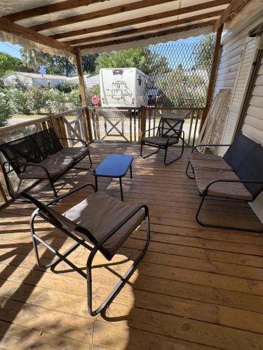 4 chaises et une table sur une terrasse en bois dans l'établissement Camping Del Mar B10, Mobile Home Excellence, 3 chambres, 6 personnes, bord de mer, à Argelès-sur-Mer