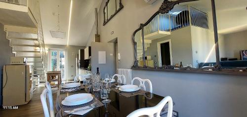 a dining room with a table with white chairs and a mirror at Il Profumo Dellegrazie in Le Grazie
