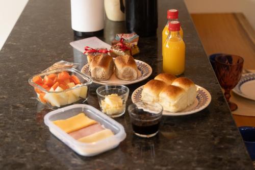 - une table avec des assiettes de nourriture et des bouteilles de jus d'orange dans l'établissement Casa 1 Villa Terra dos Cristais, à Alto Paraíso de Goiás