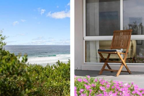 a wooden chair sitting on the porch of a beach house at Waterfront and direct beach access with views in Ulladulla