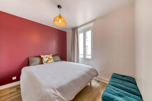 une chambre avec un lit blanc et un mur rouge dans l'établissement Cocon de Charme pour Familles, à Montreuil