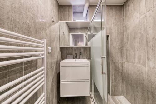 une salle de bain avec un lavabo blanc et une douche dans l'établissement Cocon de Charme pour Familles, à Montreuil