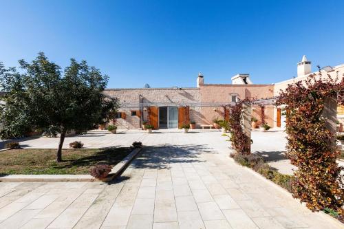 a large brick building with a courtyard in front of it at Masseria Misocampo - Happy Rentals in Calimera