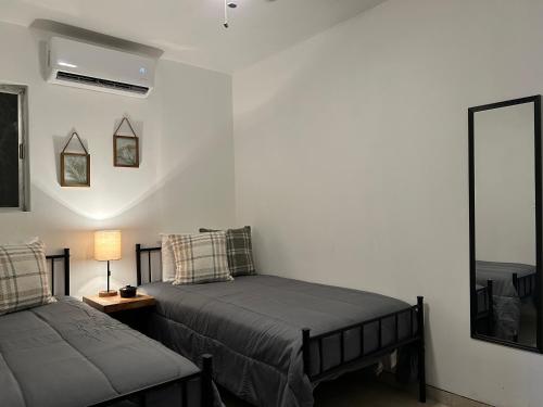 Un dormitorio con dos camas y una mesa con lámpara. en Cómodo Estudio en la Kennedy cerca de Consulado, en Nogales
