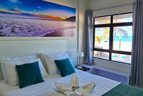 a bedroom with a bed with a picture of the beach at Apto 206 Frente Mar Elegance Flat in Natal