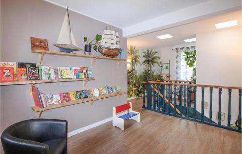 a living room with bookshelves and a chair and a staircase at Nice Home In Cléon D' Andran in Cléon-dʼAndran