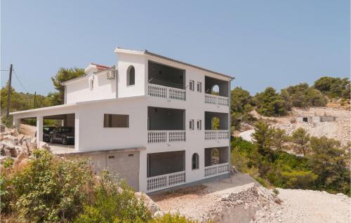 une maison blanche au sommet d'une colline dans l'établissement Amazing Apartment In Supetar-Splitska, à Splitska