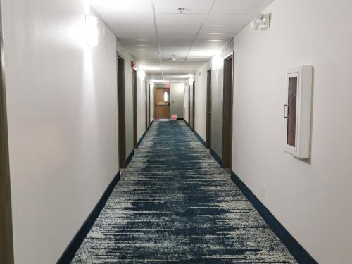 an empty corridor in an office building with a carpeted hallway at Travelodge by Wyndham Rapid City - Black Hills in Rapid City