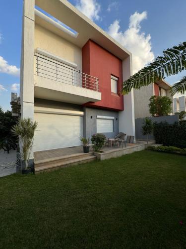 ein Haus mit einem Balkon und einem Rasenhof in der Unterkunft Luxury Villa in Madinaty in Madinaty