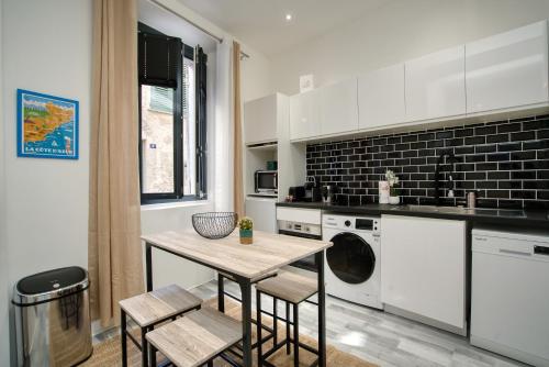 une cuisine avec une table et des chaises dans l'établissement La suite de Gambetta, à Saint-Tropez