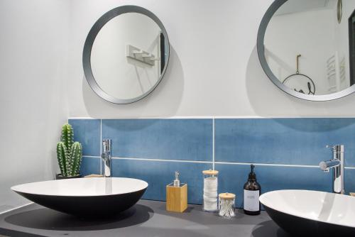 une salle de bain avec deux lavabos et un grand miroir dans l'établissement La suite de Gambetta, à Saint-Tropez