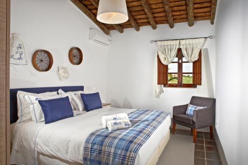 a bedroom with a bed and a chair at Herdade dos Mestres in Terena