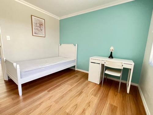 a bedroom with a desk and a bed and a table at Cindy garden in Perth