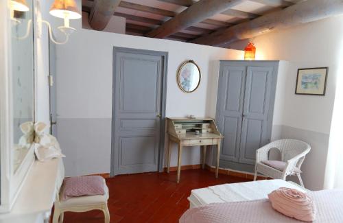 a bedroom with a bed and a table and a desk at Les Tilleuls d'Elisée in Vaison-la-Romaine