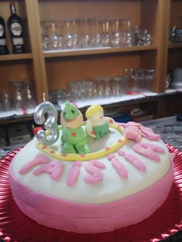 a pink and white cake with two frogs on it at Hotel Veles in Querciola