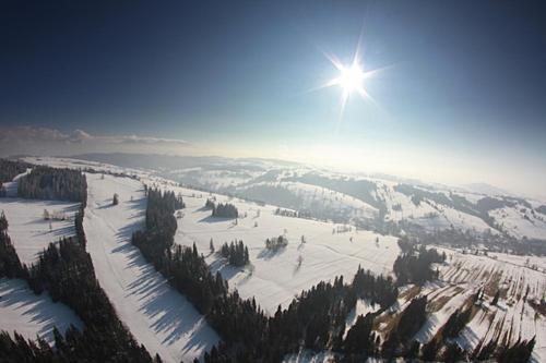 a view of a ski slope with the sun in the sky at Miętowa Górka in Ząb