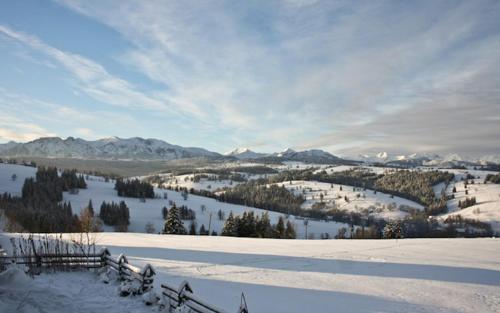 a snow covered hill with mountains in the distance at Miętowa Górka in Ząb