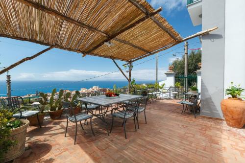 a patio with a table and chairs and a view of the ocean at Villa San Francesco in Massa Lubrense