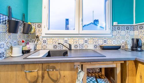eine Küche mit Spüle und Fenster in der Unterkunft La Belle De Nuit in Saint-André-les-Vergers