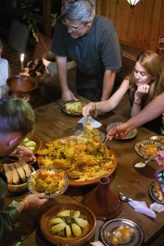 a group of people sitting around a table eating food at Imsouane soul lodge in Imsouane