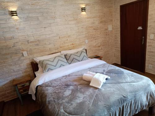 a bedroom with a bed with two towels on it at Chalé das Orquídeas in Monte Verde