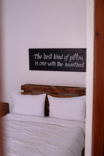 a bedroom with a bed with a sign on the wall at Imsouane soul lodge in Imsouane