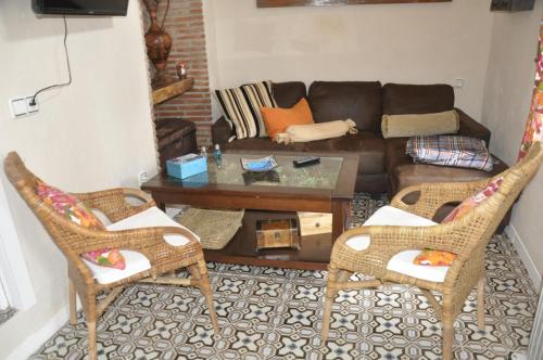 sala de estar con 2 sillas y sofá en Casa Andrea la Abuela, en Vejer de la Frontera