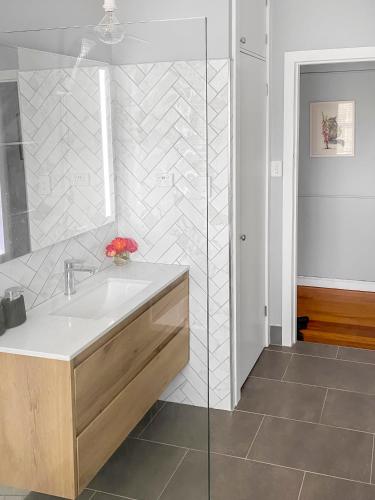 a bathroom with a sink and a shower at Rose Cottage - Pet-Friendly Cottage in Jindalee