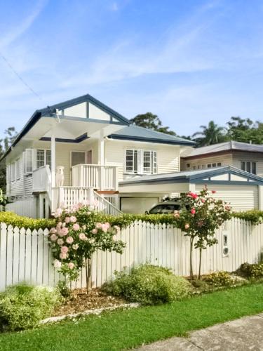a white fence in front of a house at Rose Cottage in Jindalee