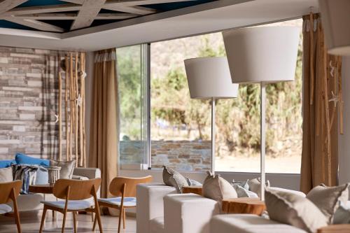 a living room with white furniture and a large window at Kythnos Bay Hotel in Loutra