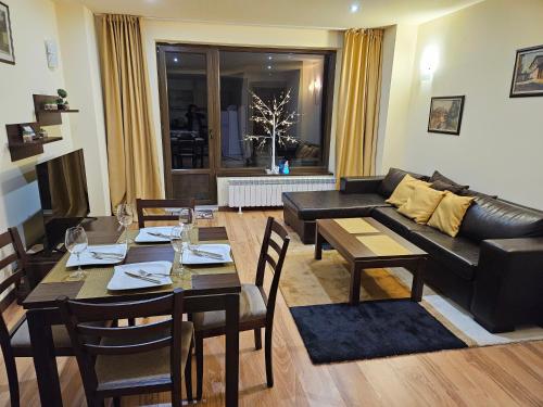 a living room with a couch and a table and chairs at TERRA KOMPLEX D3 - Private apartment - Golf, Skiing & SPA in Razlog
