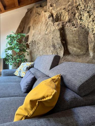 two beds in a room with a stone wall at La Pietra Gialla in Pietrapertosa