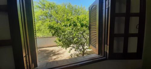 an open window with a view of a tree at Aquicho in San Marcos Sierras