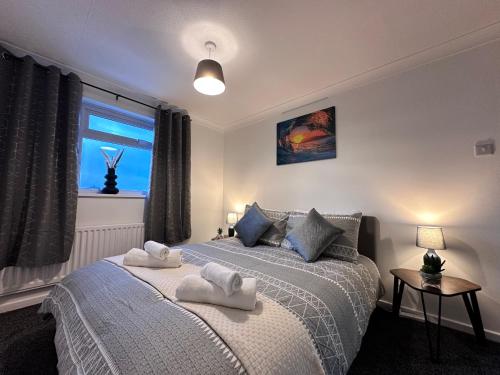 a bedroom with two beds with towels on them at Detached 3-Bedroom Home in a Quiet Derby Neighbourhood in Mickleover in Derby