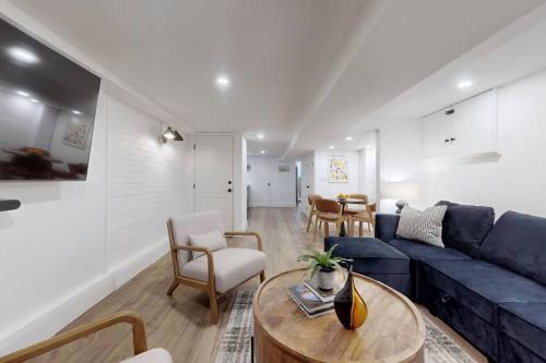 a living room with a blue couch and a table at Fresh and Modern Guest Suite in Toronto