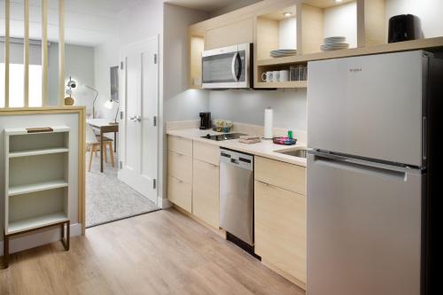 a kitchen with a white refrigerator and a table at TownePlace Suites by Marriott Grovetown in Grovetown
