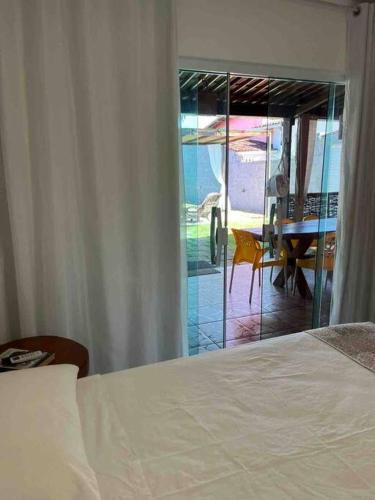 a bedroom with a bed and a view of a table at Chalé Park Mar, São José e Maragogi in São José da Coroa Grande