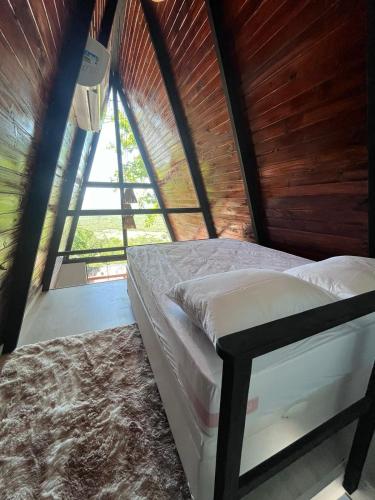 a bed in a room with a large window at Lumiar Cabanas in Rio de Janeiro