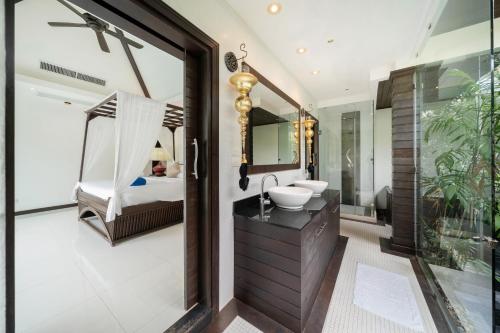 a bathroom with a sink and a bed and a mirror at Laguna luxury pool villa 3 bedroom in Phuket