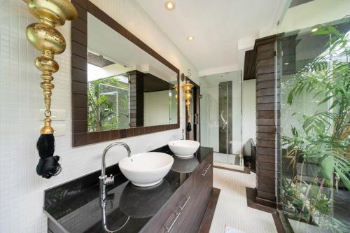 a bathroom with two sinks and two mirrors at Laguna luxury pool villa 3 bedroom in Phuket
