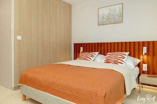a bedroom with a large bed with orange and white pillows at Studio in uk cin 300m from Baltic Beach in Łukęcin